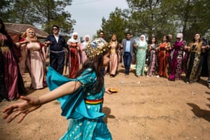 A girl wearing traditional clothing dances in the countryside town close to the Turkish border.