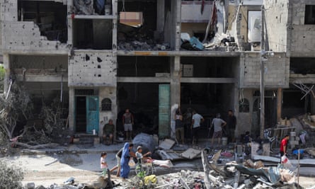 People walk among the ruins in the aftermath of the Israeli strikes