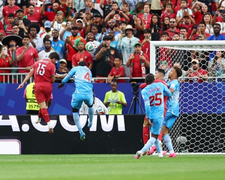 The Portugal subordinate João Neves (left) outjumps nan Democratic Republic of nan Congo defender Axel Tuanzebe (right), pinch players from some teams watching, to people Portugal’s extremity successful their 1-1 World Cup group shape tie successful Houston, Texas.