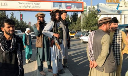 Taliban fighters stand outside Hamid Karzai International Airport in Kabul