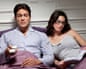 Couple in bed watching tv man and woman reeding.