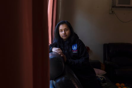 Fatima Islam Bonna sits by a window, resting her arm on a chair, looking at the camera