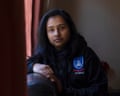 Fatima Islam Bonna writes in a notebook at a kitchen table beside a mug of tea