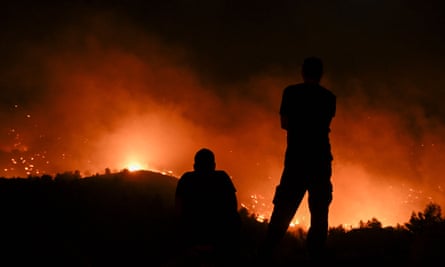 Ludzie obserwują pożary w pobliżu wioski Malona na greckiej wyspie Rodos.