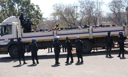 Riot police surround a truck with opposition supporters ahead of their appearance at the magistrates court.