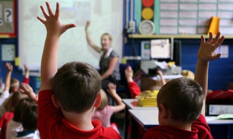 Children at school raising their hands to answer a question. 