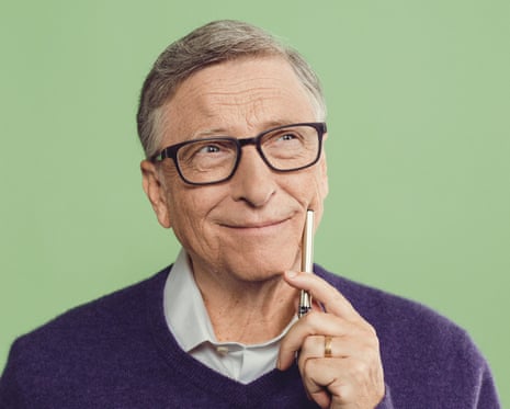 Bill Gates wearing a purple jumper against a green wall