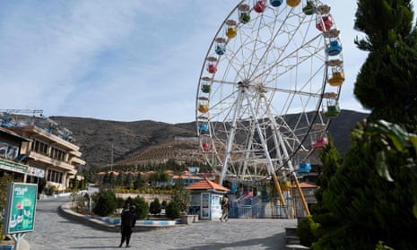 Taliban guards standing watch next to an empty ferris wheel ride at the Zazai Park on the outskirts of Kabul.
