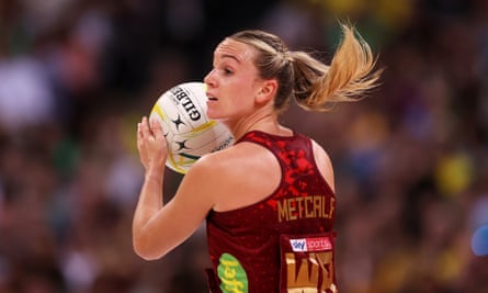 Nat Metcalf with her hair flying behind her as she holds the ball at chin height and looks to make a pass