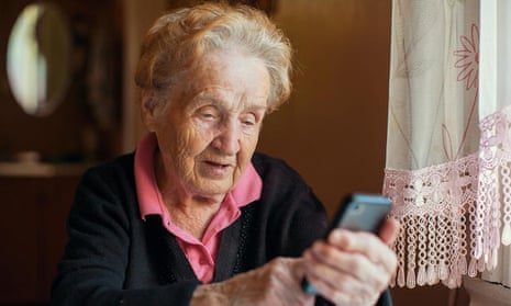 An elderly woman uses a smartphone.