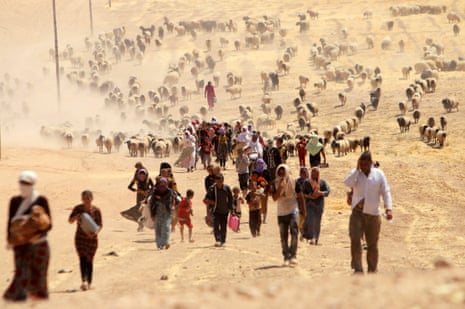 Displaced people from the minority Yazidi sect, fleeing violence from forces loyal to Isis in Sinjar town, walk towards the Syrian border, on the outskirts of Sinjar mountain, 10 August 2014.