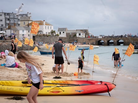 Flags on the beach protesting about second-home ownership in St Ives, Cornwall, UK, July 2024
