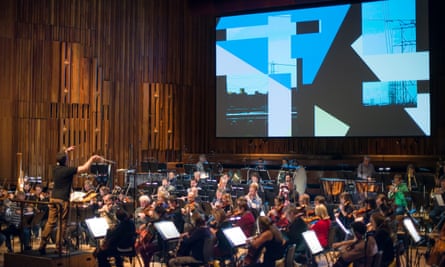 The BBC Symphony Orchestra and conductor Ryan Wigglesworth in rehearsals at the Barbican last week, with Tal Rosner’s video work as backdrop.