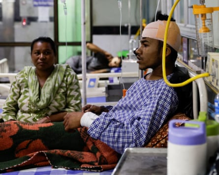 Young man in hospital bed with bandaged head and arm