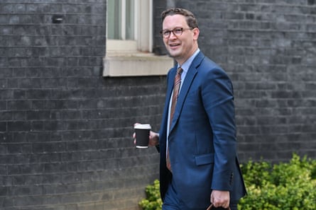 Darren Jones carries cup of coffee near Downing Street