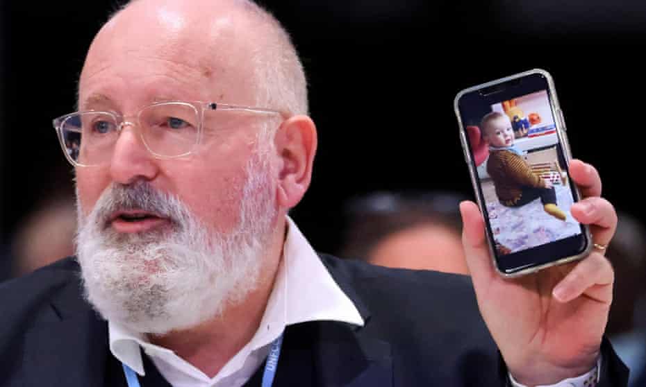 European Commission vice-president Frans Timmermans shows a picture of his grandson at COP26