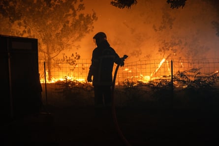 A firefighter battles a wildfire spreading in Lège-Cap-Ferret in the Gironde.