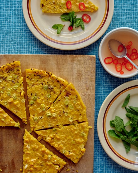 Corn farinata on a board, with slices on a plate and garnishes on other plates