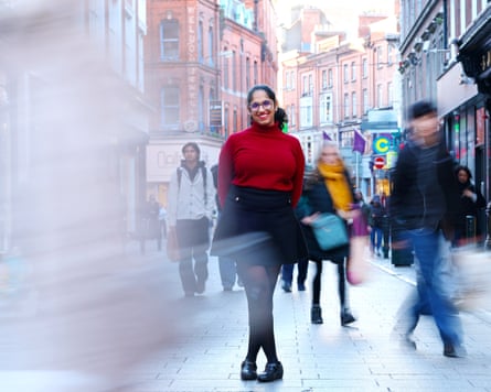 Jaishree Malik smiles on Grafton Street, Dublin, as blurred pedestrians pass by