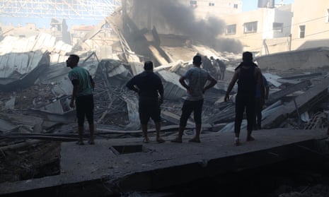 People gather at a building destroyed by an Israeli airstrike in the al-Maghazi refugee camp in the Gaza Strip.