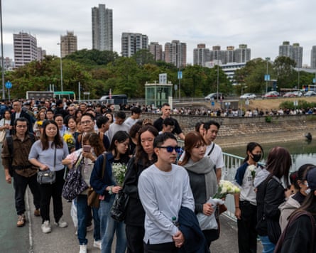 A long line of mourners with the background