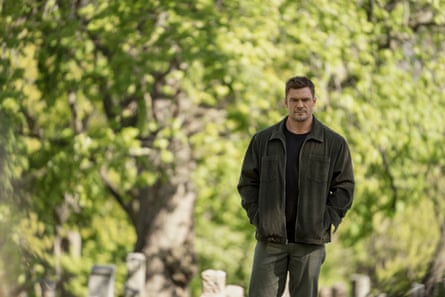 Alan Ritchson wearing dark trousers, T-shirt and jacket