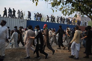Islamabad, Pakistan. Supporters of Pakistan’s former prime minister Imran Khan run as police use tear gas to disperse them outside a court