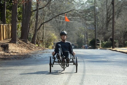 Jason Batement on a recumbent bike coming toward the camera on a leafy road