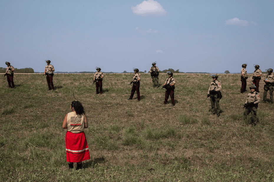 Taysha Martineau of Fond du Lac stands in front of a police line while in ceremony on land that fell in the Line 3 pipeline’s path, on 23 July 2021. Half an hour after this image was taken, she was arrested.