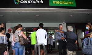 People queue outside the Centrelink office in Southport on the Gold Coast