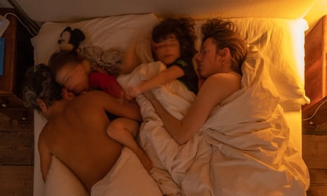 Saam and Laura in bed with their two children (time 07.15)