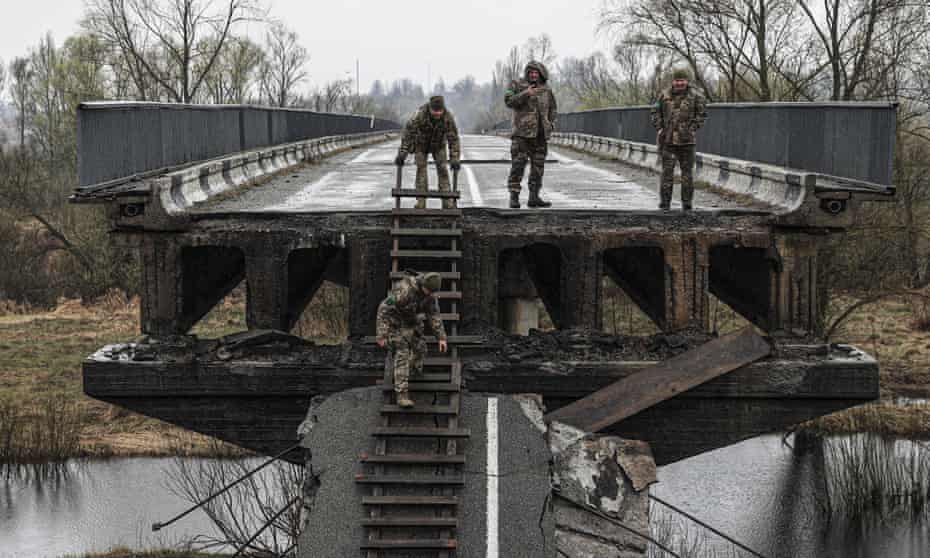 Ukrainian soldiers inspect a damaged bridge over the Teteriv river at the entrance to the Kukhari village in Borodianka, near Kyiv.