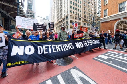 Crowds in street holding banner that says No Detentions, No Deportations