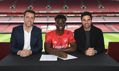 Bukayo Saka with sporting director Edu and Mikel Arteta as he signs his new deal.