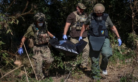 Ukrainian servicemen carry bag containing a body of a dead Russian soldier, amid Russia's attack on Ukraine, in the village of Blahodatne in Donetsk Region Ukraine September 8, 2023.