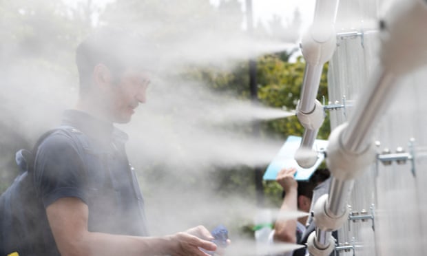 A man cools off at a mist station installed at Shiokaze Park during a beach volleyball test event