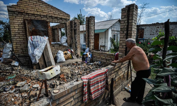 A man looks at his destroyed house in the village of Andriivka.