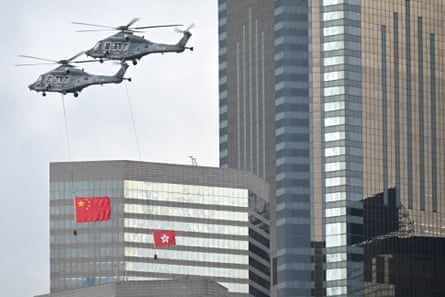 The Chinese and Hong Kong flags are flown by helicopters over Victoria Harbour during a flag-raising ceremony to mark the 28th anniversary of Hong Kong’s handover from Britain to China.
