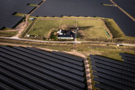 A house surrounded by rows of solar panels in Hjolderup