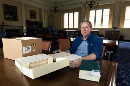 Paul Deschner at desk with box of documents.