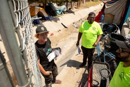 Workers pass out water, hygiene kits, and other necessities to an unhoused person