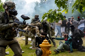 ICE and border patrol agents grab a protester outside of the Department of Homeland Security field office in Tukwila