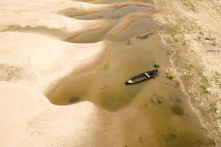 The Danube riverbed is exposed and a boat floats on a small area still containing water in Romania. The Danube riverbed is exposed and a boat floats on a small area still containing water in Romania.