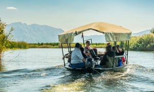 Visitors take a boat trip in the Neretva river delta and are entertained by tradtional musicians.