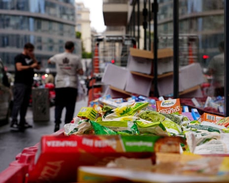Spoiled packaged food items piled in crates outside a Paris supermarket after a cyberattack