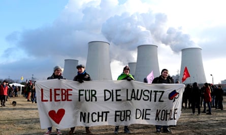 Climate activists in front of the coal-fired Jaenschwalde power station in the Lausitz region, Germany, protesting against open-cast mining in November 2019. Their banner reads: ‘Love for the Lausitz. Not for the coal.’