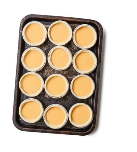 fill the cases by three-quarters with custard. Working quickly, put the tins on the hot sheets and bake for about 10 minutes, until the pastry is dark golden and the custard starting to brown in spots