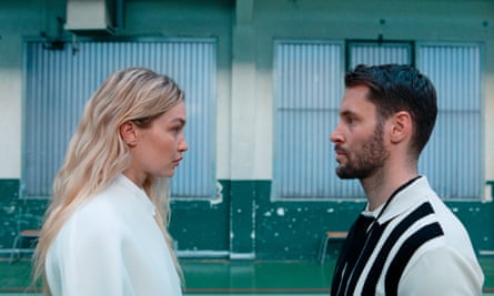 A head-and-shoulders photo of a woman and a man facing each other on a sport court.