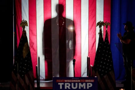silhouette of man behind large US flag