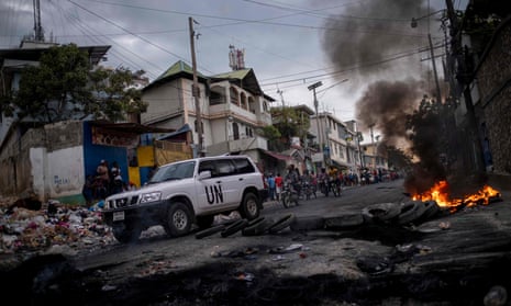 A UN vehicle drives past a barricade of burning tires during a demonstration against high prices and fuel shortages in Port-au-Prince, Haiti, on Thursday.